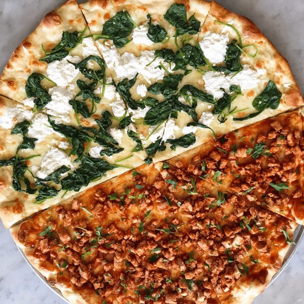 A Joe's pizza with half spinach and ricotta, and half diced chicken with parsley.