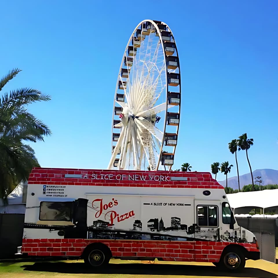 Joe's Pizza food truck with a red brick design, parked in front of a large Ferris wheel.