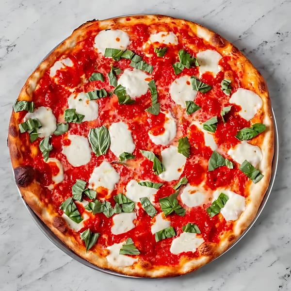 Joe's Pizza classic Margherita pizza with fresh mozzarella, vibrant tomato sauce, and basil on a marble surface.